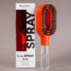 Orange cleaning comb with clear handle next to its packaging on a gray background
